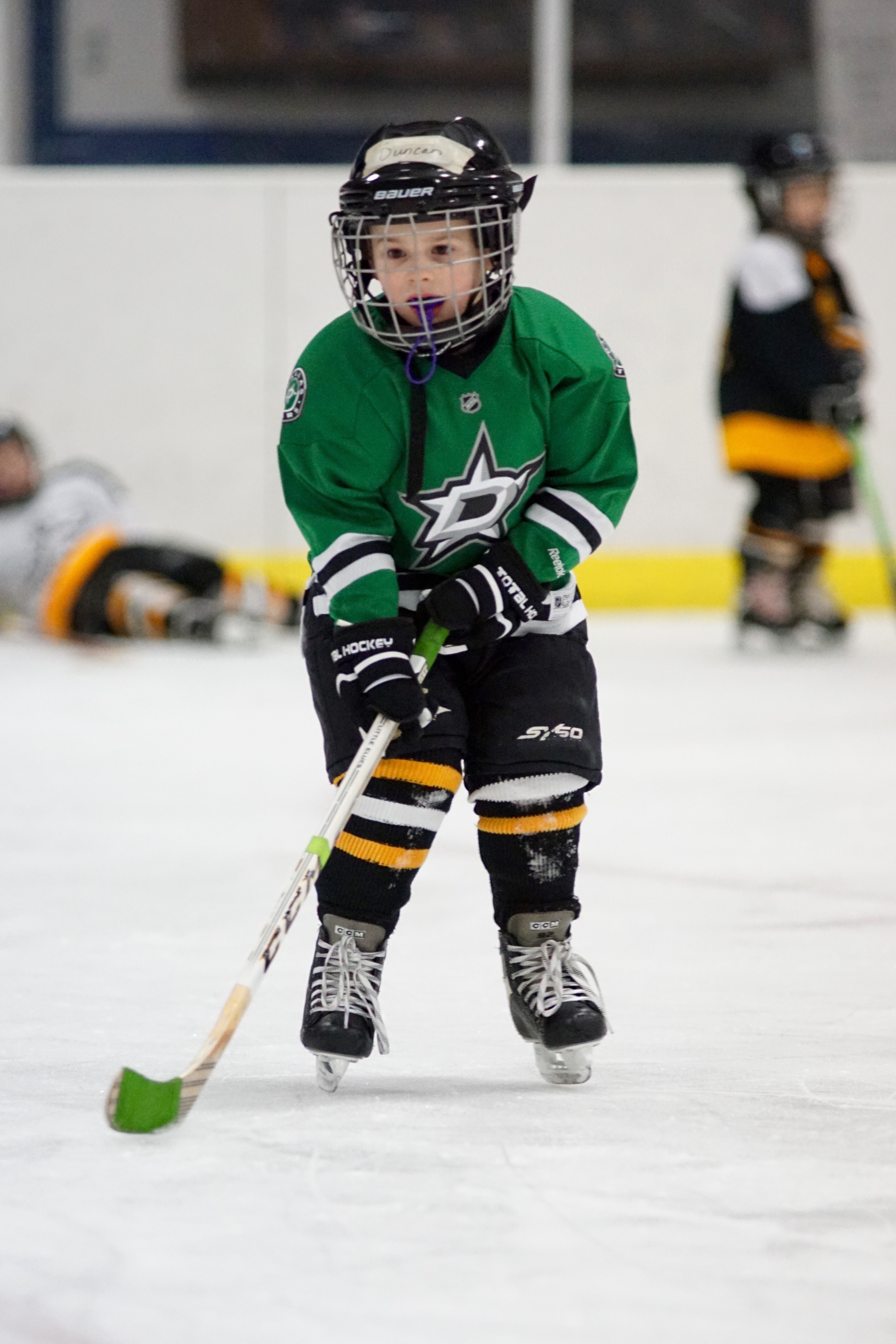 Boy in green jersey playing hockey
