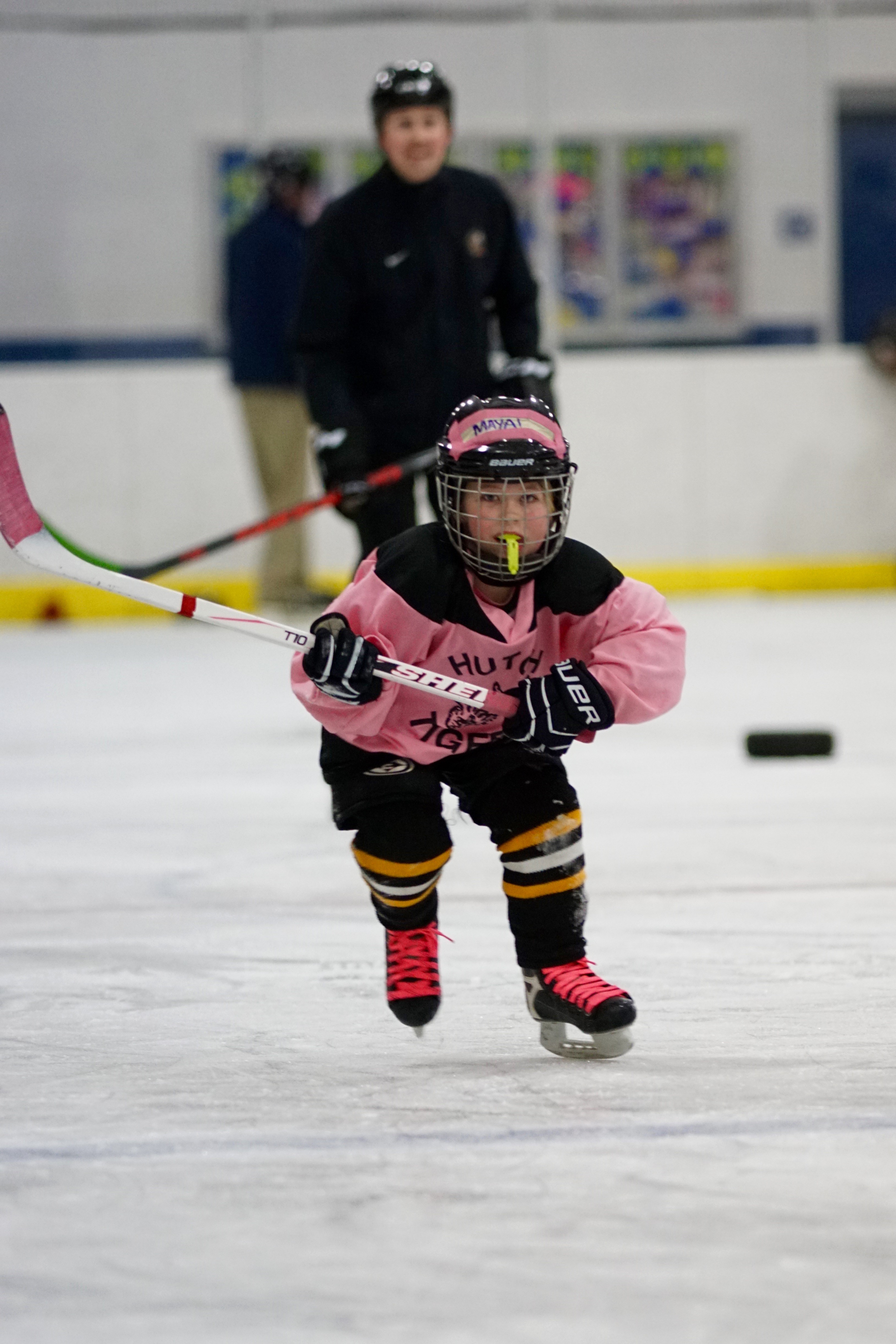 little girl in pink jersey playing hockey