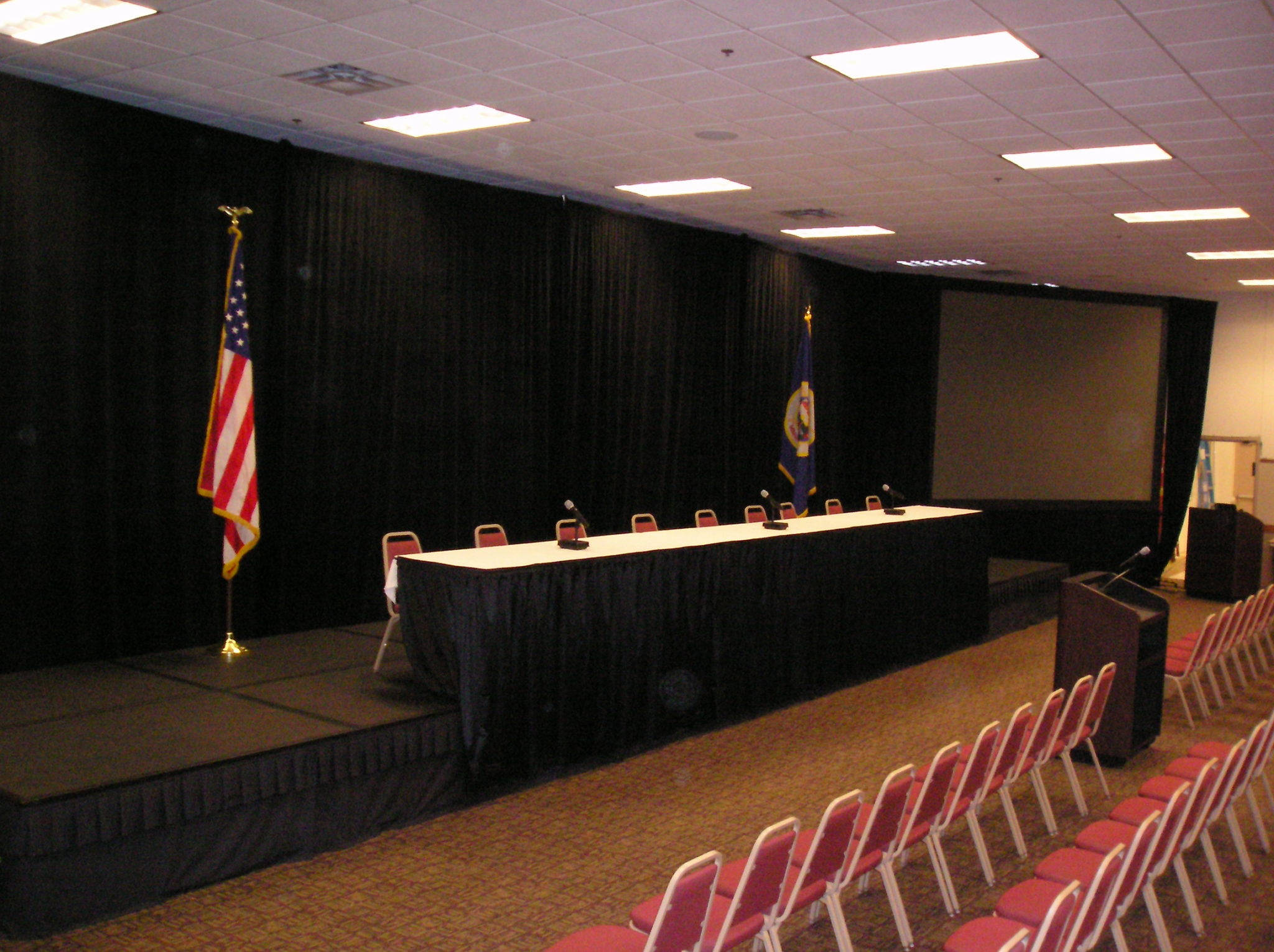 head table with flags on each side on a stage