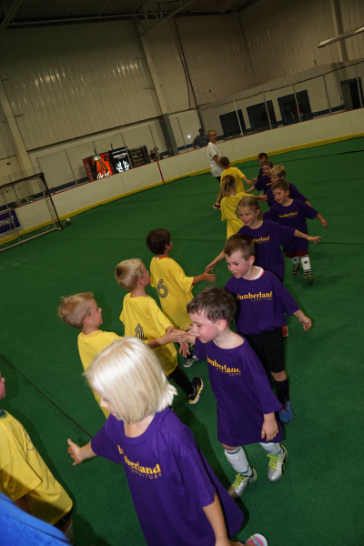 boys soccer team giving high five to opponents