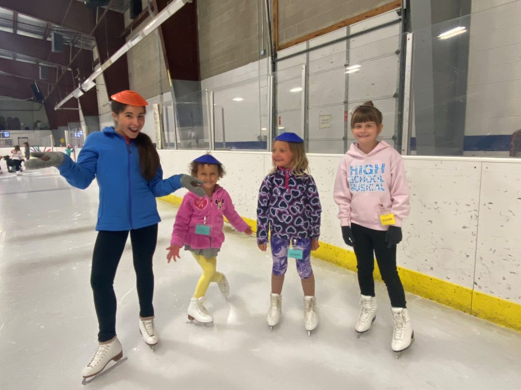 Four young figure skaters having fun on the ice rink. 