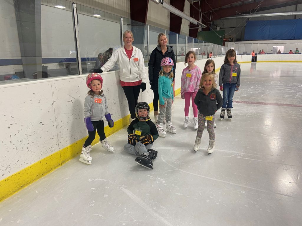A group of young skaters and 2 instructors on the ice at Burich Arena. 