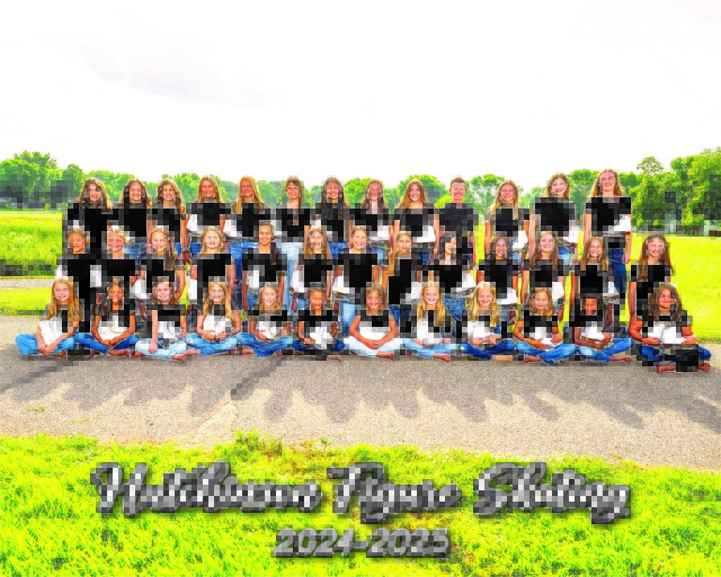 A large group of girls and one boy pose outdoors in matching black shirts and jeans. Text at the bottom reads “Hutchinson Figure Skating 2024-2025.” The background shows green grass and trees.